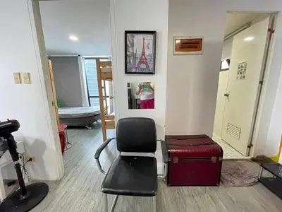 a room with a chair and a suitcase at Modern Condotel in Ortigas good up to 8 pax in Manila