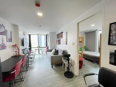 a living room with a couch and a table and chairs at Modern Condotel in Ortigas good up to 8 pax in Manila