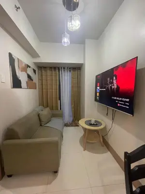 a living room with a couch and a flat screen tv at Gen Travel Hub in Manila