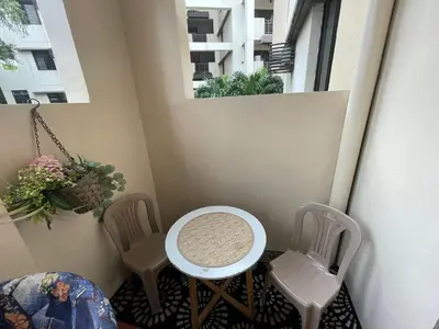 a small balcony with two chairs and a table and a window at 3 bedroom 89sqm midrise condotel in Manila