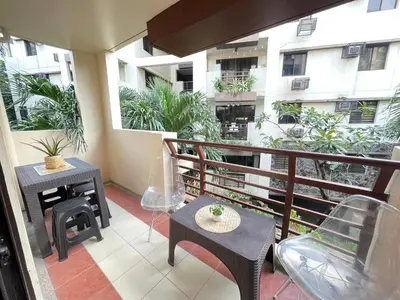 a balcony with a table and chairs and a building at 3 bedroom 89sqm midrise condotel in Manila