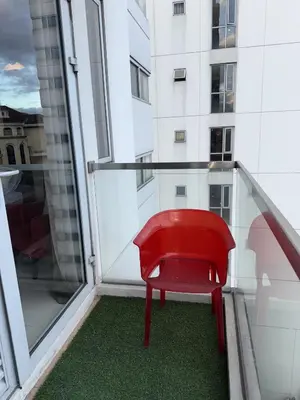 a red chair on a balcony with a building at Bnb88C Condotel in Manila