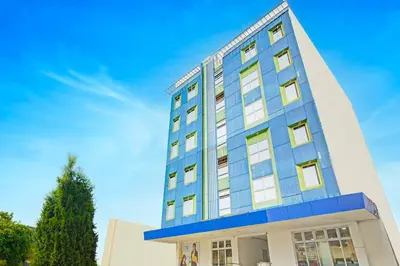 a blue and white building with a tree at Townhouse College Residences in University Belt, Metro Manila in Manila