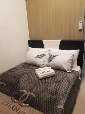 a bed with white pillows and a tray on it at Shore2n3 Residences MOA Pasay City Near NAIA Airport in Manila