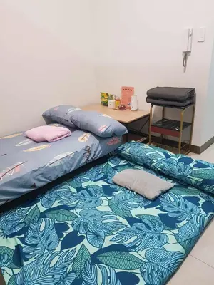 two beds in a room with a desk and a table at Shore2n3 Residences MOA Pasay City Near NAIA Airport in Manila