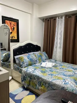a bedroom with two beds and a mirror at Collins Condotel in Manila