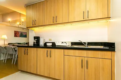 a kitchen with wooden cabinets and a sink at 2BR in Central BGC in Manila