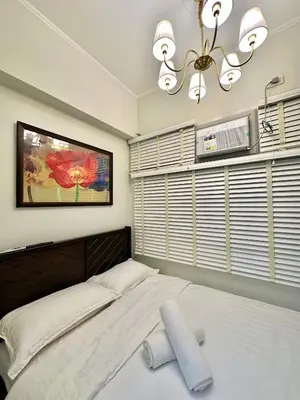 a bedroom with a large bed and a fan at Studio Two Condominium, Alabang Northgate Cyberzone, DOVE-Fiber Wi-Fi Netflix ready in Manila