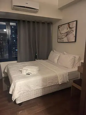 a bedroom with a large bed with white sheets at Destina, 100Mbps at Air Residences, Makati, MetroManila, Netflix in Manila