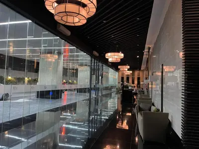 a lobby of a building with glass walls and chandeliers at Destina, 100Mbps at Air Residences, Makati, MetroManila, Netflix in Manila