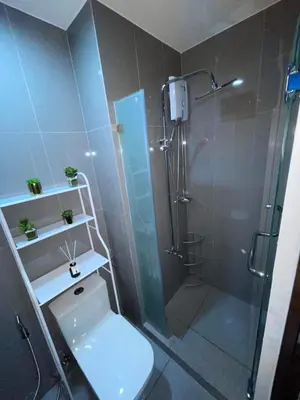 a bathroom with a shower with a toilet and a glass shower stall at Destina, 100Mbps at Air Residences, Makati, MetroManila, Netflix in Manila