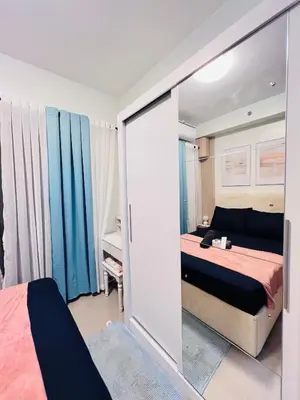 a bedroom with a bed and a mirror at Cozy Suite Pool View in Shore 2 Residences near SM MOA in Manila