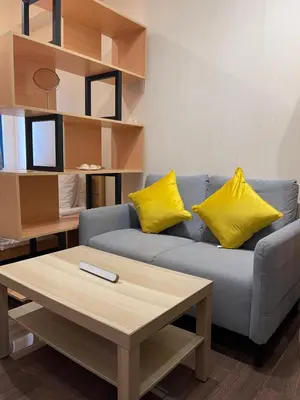 a living room with a blue couch with yellow pillows at Destina, 100Mbps at Air Residences, Makati, MetroManila, Netflix in Manila