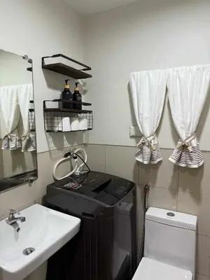 a small bathroom with a sink and a black stove at Stylish and Comfy Condominium in Manila