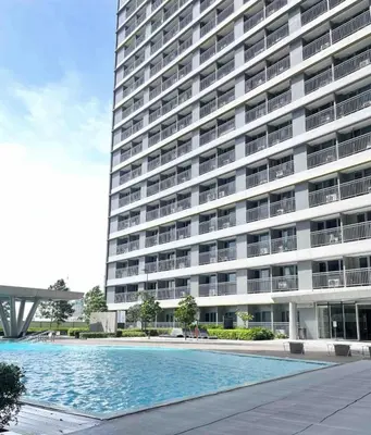 a large building with a swimming pool in front of it at Staycation Bliss at Fame in Manila