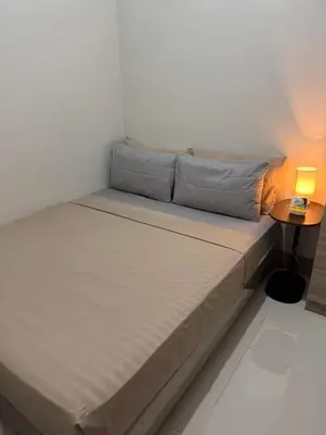 a bed in a room with a lamp on a table at M S Staycation in Manila