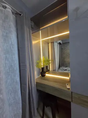 a bathroom with a mirror and a table with a plant at Cozy Corner at Shore 2 in Manila