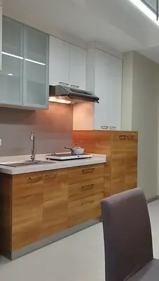 a kitchen with wooden cabinets and a sink and a chair at Premium Studio in Pioneer Mandaluyong in Manila