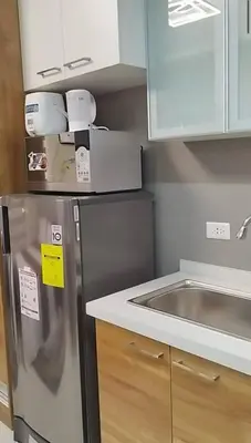 a kitchen with a stainless steel refrigerator and a sink at Premium Studio in Pioneer Mandaluyong in Manila