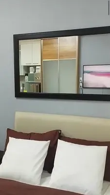 a mirror above a bed with two pillows at Premium Studio in Pioneer Mandaluyong in Manila