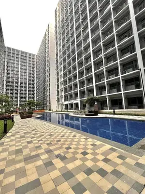 a large building with a swimming pool in front of it at Staycation Shore 2 Residences Tower 2 Pasay City in Manila