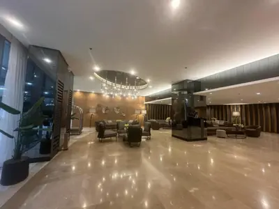 a lobby with couches and chairs and a chandelier at Shore Residences Apartment Condo Staycation in Manila