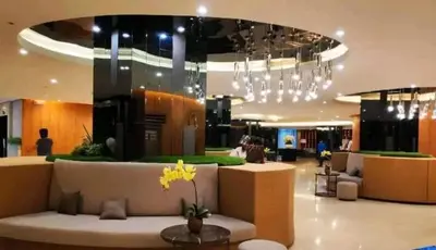 a lobby with a couch and chandelier in a building at Shore Residences Apartment Condo Staycation in Manila