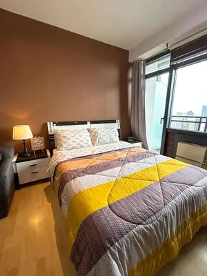 a bedroom with a bed and a large window at High Sunset View with Fast WiFi, Pool, Big Balcony, Gym Access in Manila