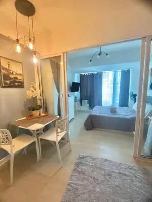 a living room with a bed and a table and chairs at Condotel Azure Beachview in Manila