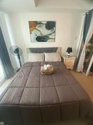 a bedroom with a large bed with a teddy bear on it at Condotel Azure Beachview in Manila