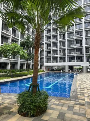 a palm tree in front of a large building at Shore 2 Staycation nice Homes in Manila