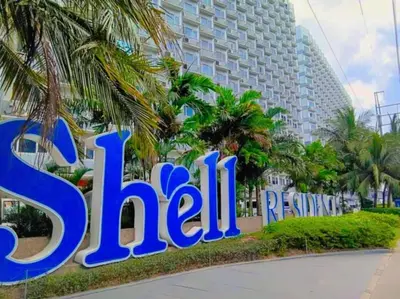 a sign for a hotel in front of a building at Family room big balcony pool view 2F in Manila