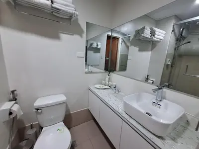a white bathroom with a toilet and a sink at 2BR Apartment plus FREE parking Near NAIA in Manila