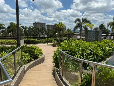 a walkway in a park with trees and plants at Cozy Place near Eastwood in Manila