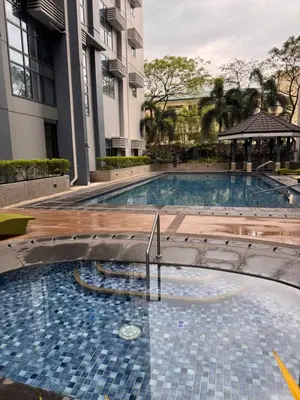 a large swimming pool in front of a building at Condo in Mckinley Hill Taguig in Manila