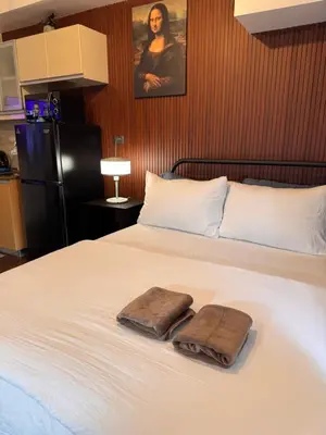a bedroom with a bed with two towels on it at Condo in Mckinley Hill Taguig in Manila