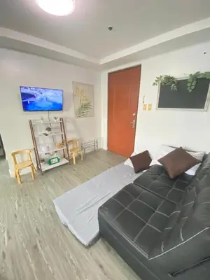 a bedroom with a large bed and a tv at 2 BR Unit with 180 degree view in Ortigas in Manila