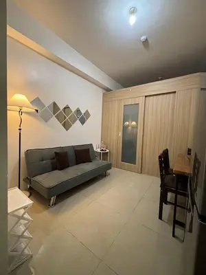 a living room with a couch and a table and chairs at Condo in Pasay in Manila