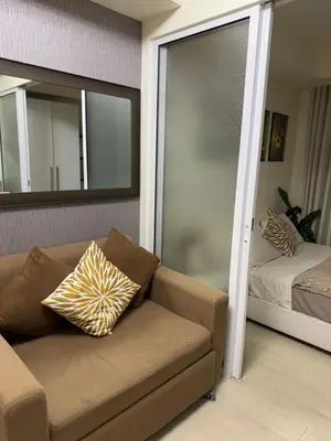 a living room with a couch and a mirror at Miami 1909 in Manila