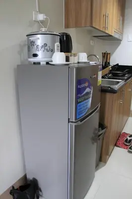 a kitchen with a refrigerator with a pot on top of it at Cozy Urban Nest in Manila