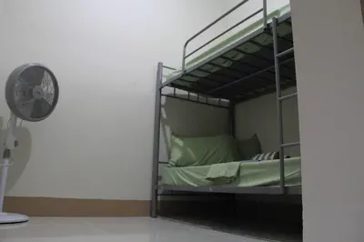 a bunk bed in a room with a fan at Cozy Urban Nest in Manila