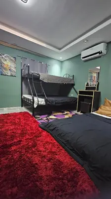 a bedroom with a bed and a red rug at Natural Haven with Netflix Kubo Videoke & Alfresco Dining in Dasmariñas