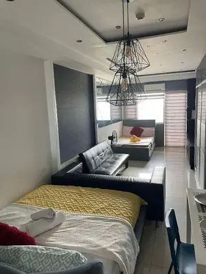 a living room with two beds and a couch at 1553 Moa view bigcut in Manila