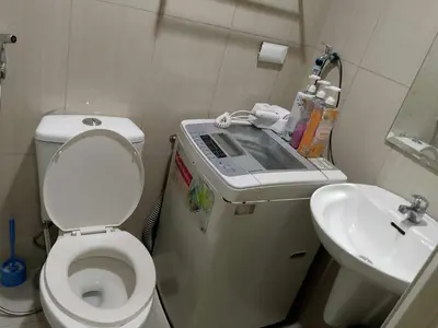 a small bathroom with a toilet and a sink at 1103- 1bedroom 1 sofa bed 1 folding bed in Manila
