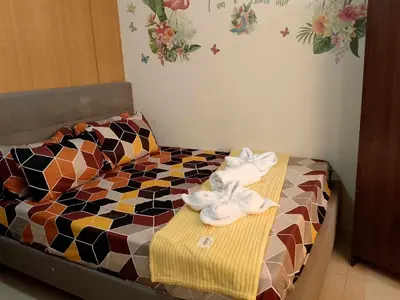 a bed with two towels on top of it at 1103- 1bedroom 1 sofa bed 1 folding bed in Manila
