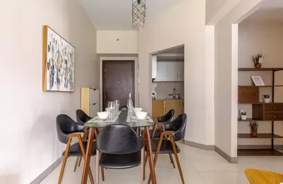 a dining room with a table and black chairs at BGC Taguig Uptown 3BR corner unit with pool view, bath tub, wifi, parking, beside Landers BGC in Manila
