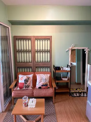 a living room with a couch and a table at Affordable Cozy Plage by Martian in Manila