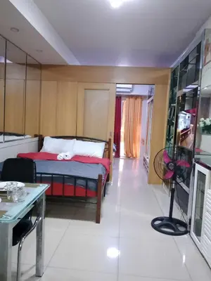 a bedroom with a bed and a table in it at 257 moa view with balcony bigcut in Manila