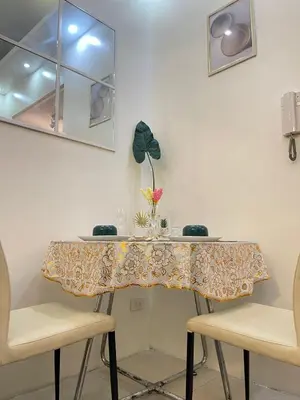 a table with two chairs and a table cloth on it at Orchids Shore Residences Direct Pool Access in Manila