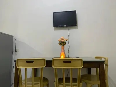 a table with two chairs and a vase with flowers at Ballentos staycation in Manila